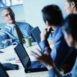 Businesspeople Using Laptops During Meeting