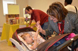 Mayor Teresa Jacobs and one of her youngest residents share a special moment at a Holiday Heroes Toy Drive distribution event in 2013.